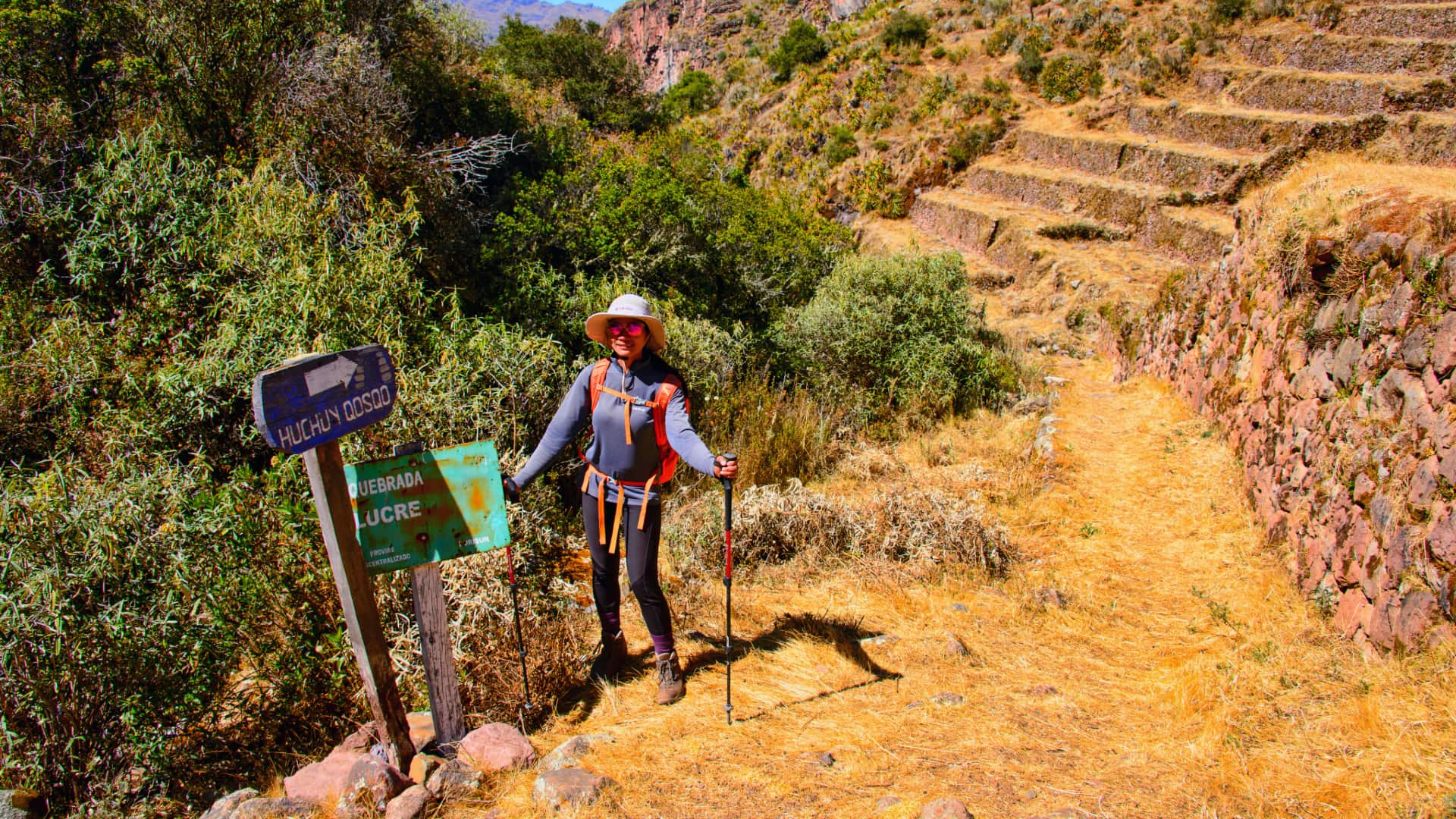 Hikers making their way up a steep stone staircase carved into the mountainside.